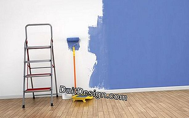 Maler en vegg med peeling maling