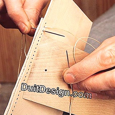 Primeiro, enfie a agulha no primeiro orifício e distribua a linha uniformemente em ambos os lados da costura.